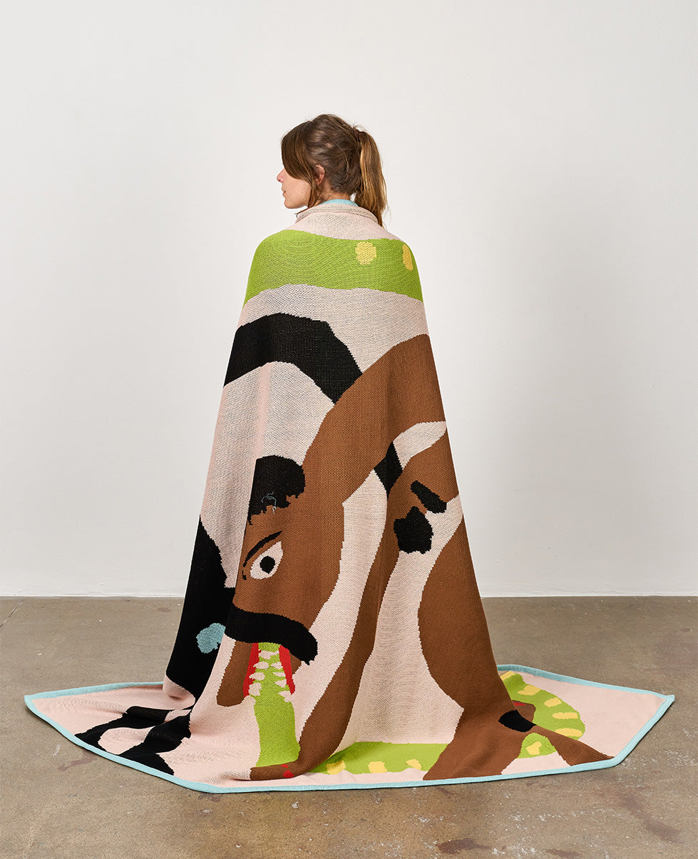 Limited edition of 50 artist blanket by Cassi Namoda. Woman posing with the blanket.